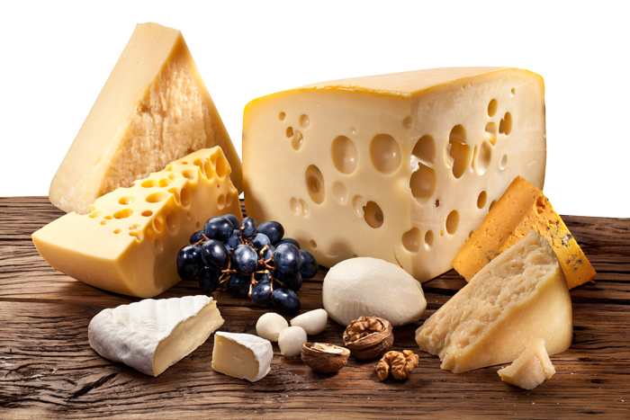 Different types of cheese over old wooden table. File contains clipping paths.